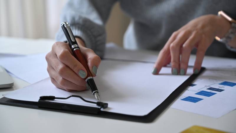 Employee writing at a desk